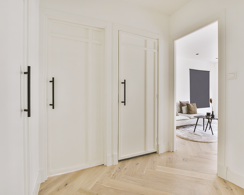 detalle de casa con puertas blancas y suelo claro de madera
